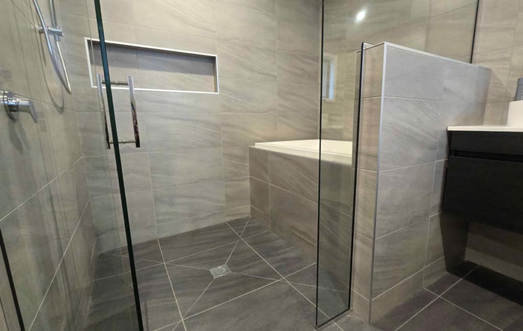 Calyx deep soaking tub, installed in a glass bathroom enclosure beside a walk-in shower.