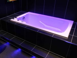 The Nirvana deep soaking tub in a tiled setting, underlit